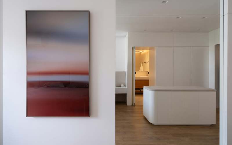 Close-up of hands installing a modular 3D wall art panel in a minimalist bedroom